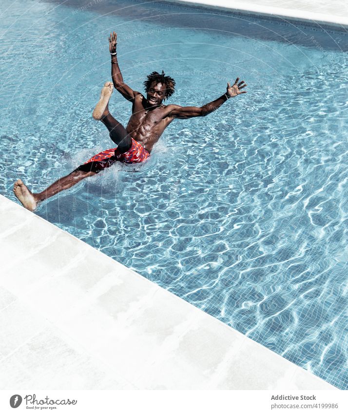Schwarzer Mann fällt in Pool fallen Erstaunen ausrutschen Schock erstaunt Browsen Beckenrand männlich ethnisch schwarz Afroamerikaner Mobile Telefon benutzend