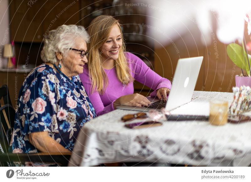 Erwachsene Enkelin bringt ihrer älteren Großmutter den Umgang mit dem Laptop bei Menschen Frau Senior reif lässig Kaukasier heimwärts Haus alt Alterung
