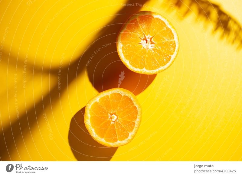 2 Orangen im Frühling mit gelbem Hintergrund Lebensmittel Frucht Frische saftig Vitamin Zellstoff frisch Farben Nährstoffversorgung Zitronensäure fruchtig