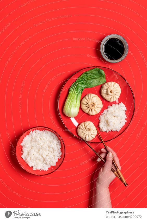 Essen mit Stäbchen chinesische gedünstetes Essen, Ansicht von oben auf einem roten Hintergrund. asiatisch Bao Bapao Bok Choi Schalen & Schüsseln Brötchen