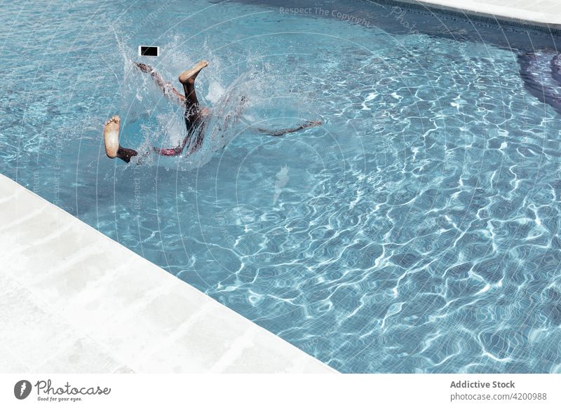 Unbekannter schwarzer Mann fällt in Swimmingpool fallen Pool Smartphone platschen Wasser Beckenrand Wassertropfen Tropfen männlich ethnisch Afroamerikaner