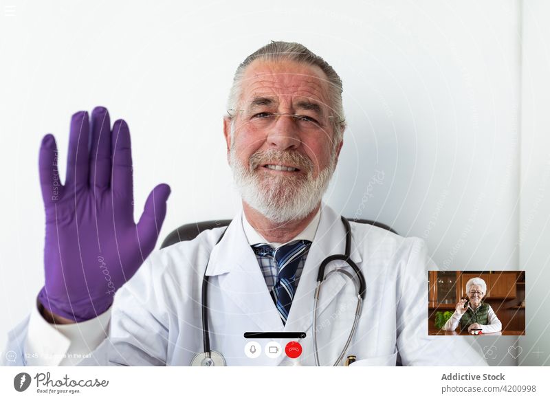 Älterer Arzt gegen Laptop bei Online-Gesundheitsberatung in der Klinik arzt Gruß Videoanruf Gesundheitswesen Beratung online Internet Mann benutzend Apparatur