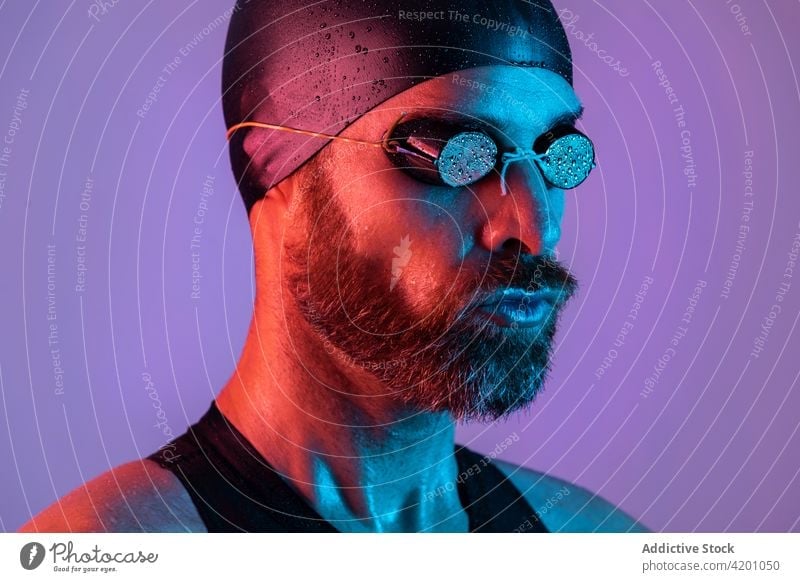 Seitenansicht Studio-Porträt eines Schwimmers mit Kappe und Schwimmbrille Atelier Mann Hintergrund Verschlussdeckel Brille bärtig Gesundheit Gesicht jung