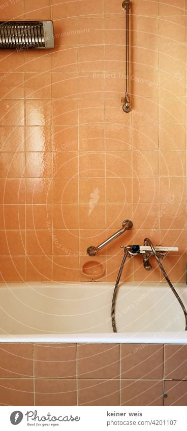 Altes Badezimmer in orange mit elektrischem Heizstrahler und Wasserhahn mit Duschkopf Fliesen u. Kacheln Häusliches Leben Badewanne Menschenleer Farbfoto