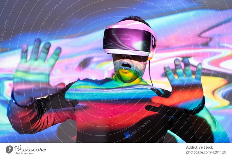 Mann mit VR-Brille erkundet virtuelle Realität Virtuelle Realität Headset Schutzbrille berühren Erfahrung erkunden leuchten Projektor Technik & Technologie