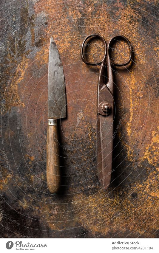 Alte Metallschere und Messer auf dem Tisch Rust Schere alt schäbig verwittert Oberfläche gealtert Instrument Werkzeug Grunge Stahl dunkel Gerät metallisch