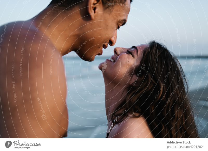 Junger schwarzer Tourist küsst glückliche Geliebte gegen das Meer Freund Kuss Freundin Partnerschaft Liebe herzlich romantisch Flitterwochen reisen MEER Umarmen