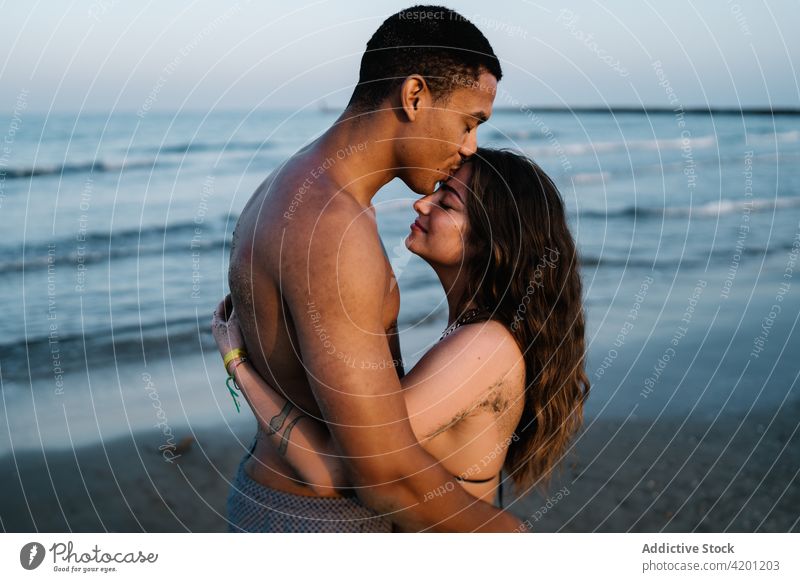 Junger schwarzer Tourist küsst glückliche Geliebte gegen das Meer Freund Kuss Freundin Partnerschaft Liebe herzlich romantisch Flitterwochen reisen MEER Umarmen