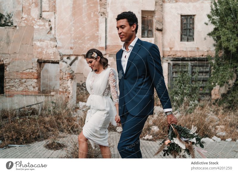 Inhalt vielfältig frisch verheiratetes Paar zu Fuß auf dem Bürgersteig gegen alte Gebäude Jungvermählter Liebe Partnerschaft altehrwürdig Spaziergang