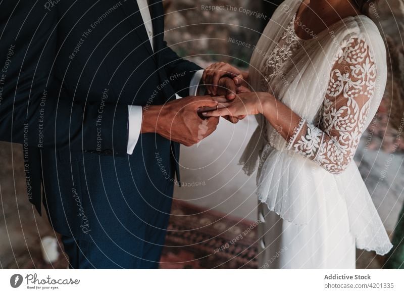 Anonymes Brautpaar, das sich den Ehering an den Finger steckt Paar Jungvermählter Ring Hochzeit Händchenhalten Angebot Zuneigung ausgefallen Anlass Inhalt