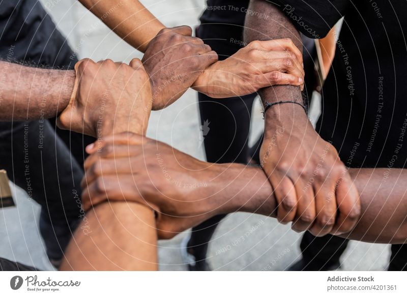Gesichtslose schwarze Freunde reichen sich auf dem Bürgersteig die Hände Einheit Händchenhalten Menschenrechte Gemeinschaft kooperieren abstützen beitreten Team