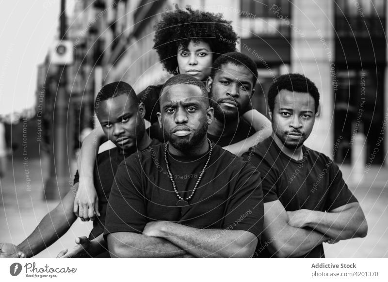 Selbstbewusste schwarze Freunde umarmen sich auf der Straße der Stadt Umarmen selbstsicher die Arme verschränkt Freundschaft selbstbewusst ernst Team Porträt
