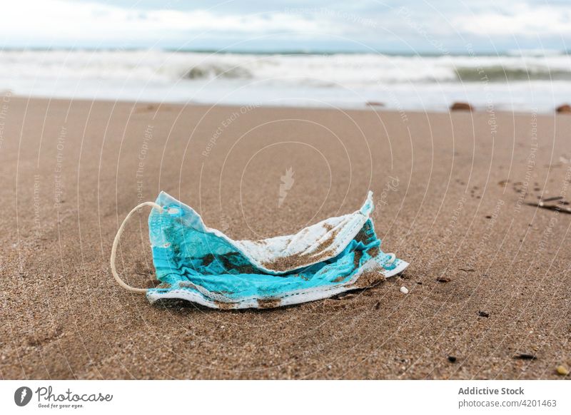Schmutzige medizinische Maske am sandigen Meeresstrand Mundschutz verschmutzen MEER Strand Abfall Umwelt Konzept Kunststoff Müll Wasser verwendet dreckig