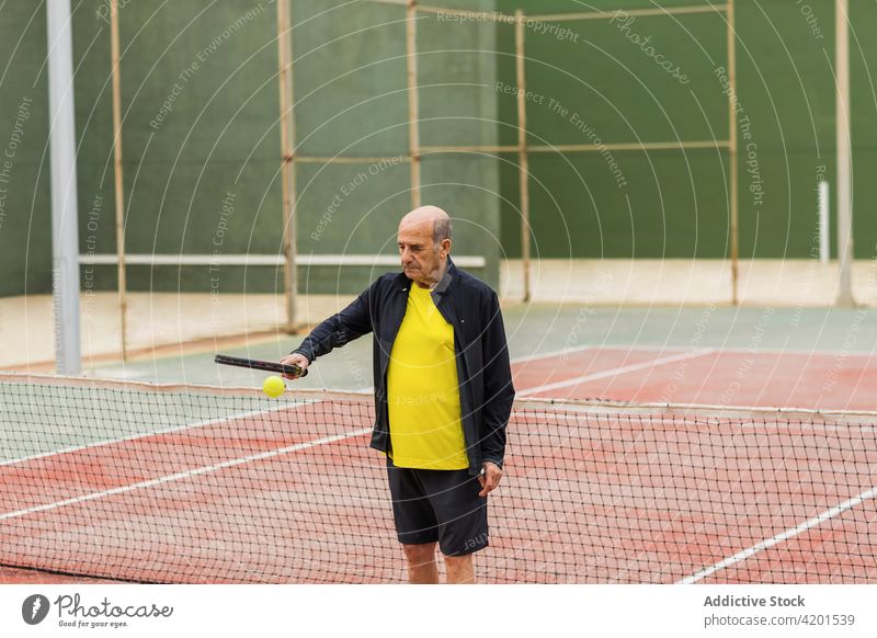 Älterer Tennisspieler prellt Ball auf Schläger Sportler hüpfen Gericht Training Streichholz vorbereiten Remmidemmi männlich Spiel Athlet Senior gealtert älter