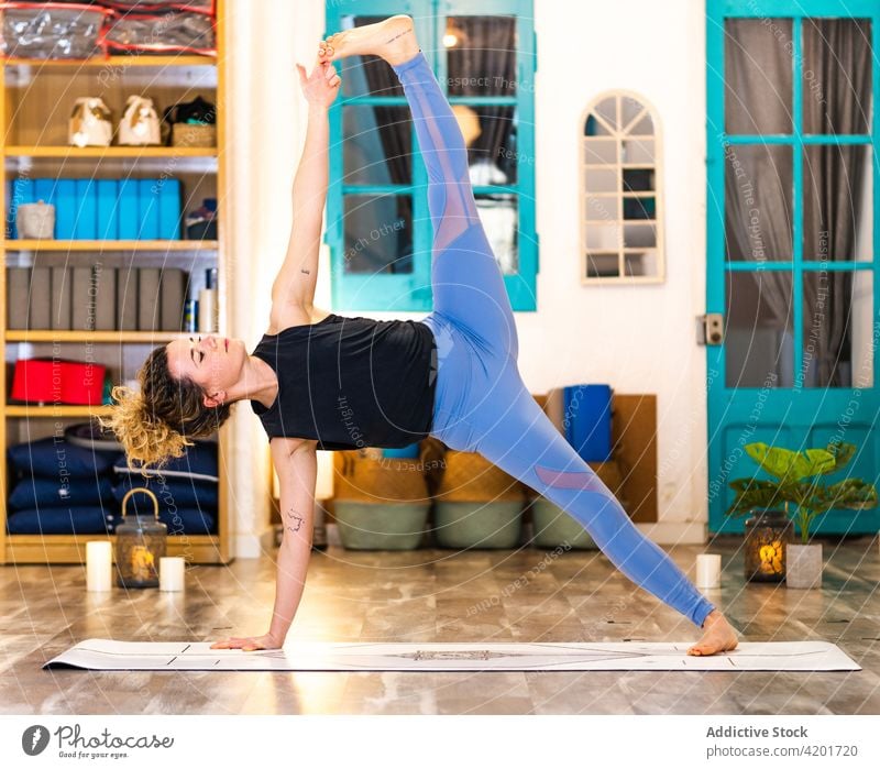 Schlanke Frau in der erweiterten seitlichen Plank-Pose, während sie Yoga zu Hause praktiziert Windstille ruhig ausgestreckte Seitenplanke Asana Wellness üben