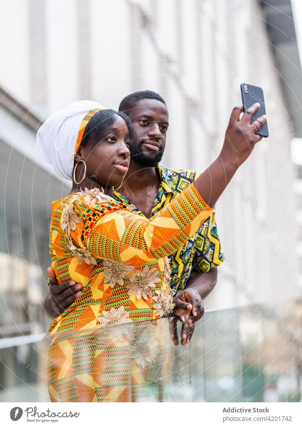 Glückliches schwarzes Paar macht Selfie mit Smartphone in der Stadt Moment Gedächtnis Partnerschaft Liebe Inhalt Porträt benutzend Apparatur Gerät Lächeln