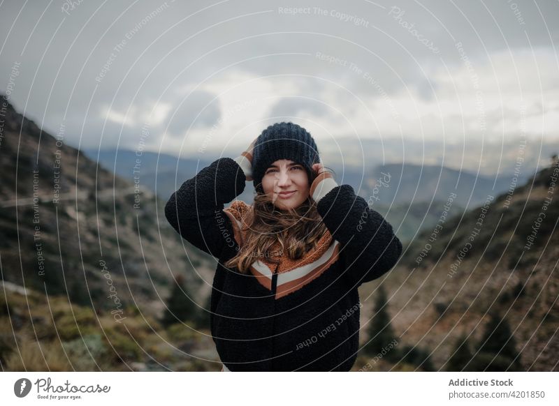 Fröhliche Frau, die im malerischen Hochland einen Hut aufsetzt Mann angezogen wolkig trist heiter Lächeln Natur Wetter Glück jung schön Freude Cadiz Spanien