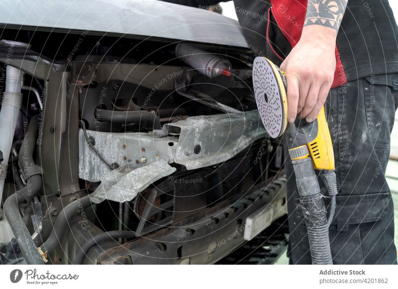 Crop Mann poliert Auto im Dienst abrauen PKW polnisch Mechaniker vorbereiten Maschine Automobil Werkstatt Grinden männlich Verkehr Arbeit Job Werkzeug Garage