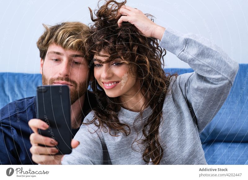 Glückliches Paar macht Selfie mit Smartphone Zusammensein heiter Lächeln Liebe Selbstportrait Mobile Telefon lässig benutzend Moment Umarmung Umarmen Gedächtnis