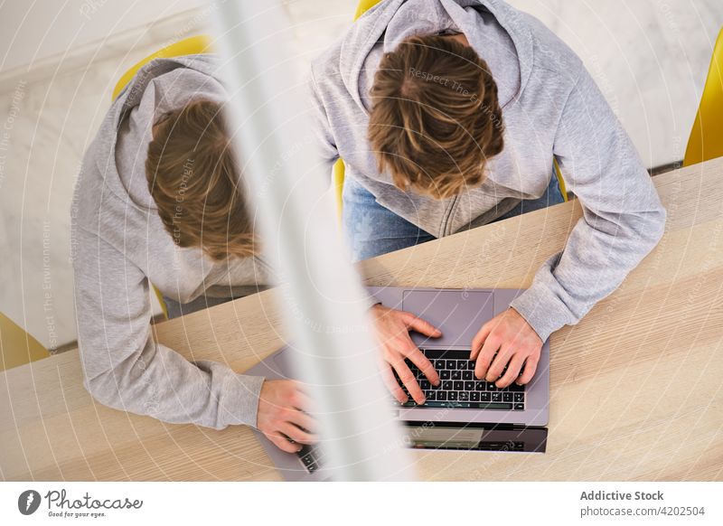 Gesichtsloser Mann arbeitet aus der Ferne an einem Laptop in einem Raum freiberuflich heimwärts modern Arbeit selbständig Arbeitsplatz Job Beruf männlich