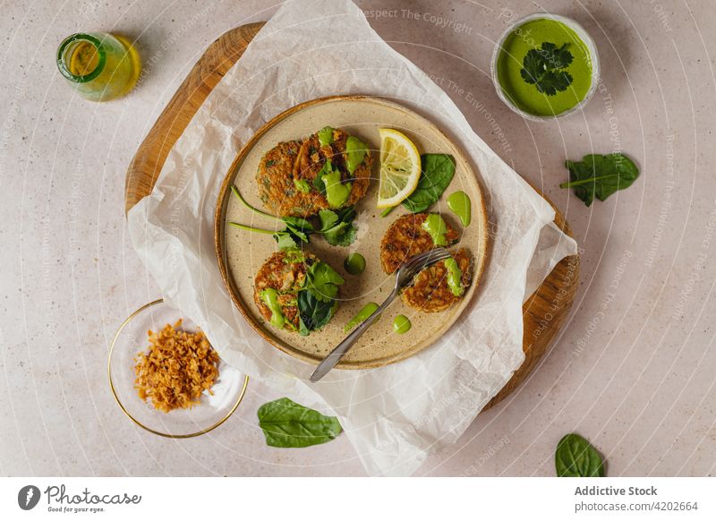 Frische gesunde Krapfen, serviert auf einem Teller mit einer Zitronenscheibe Fritter Kotelett Kräuterbuch Gesundheit appetitlich Zusammensetzung Lebensmittel