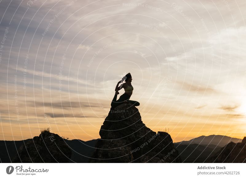Unbekannte Frau genießt Yoga auf Felsformationen Sonnenuntergang Berge u. Gebirge Meerjungfrau Asana Harmonie Gleichgewicht Silhouette beweglich