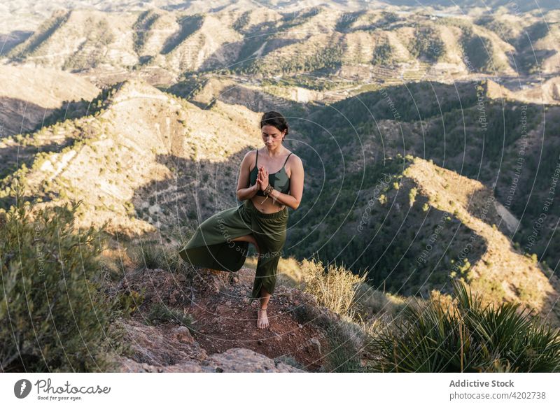 Frau in Vrksasana auf einer Bergkuppe Yoga Baumhaltung Erholung Gebetshände meditieren Augen geschlossen Natur beweglich selbstbewusst Berge u. Gebirge