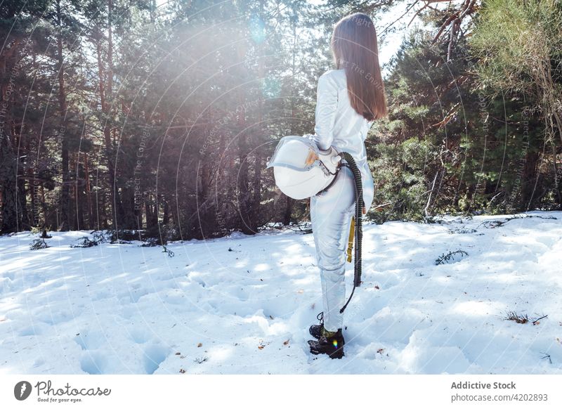 Anonyme Astronautin im verschneiten Wald stehend Frau Schnee Kosmonaut Raumanzug Windstille Winter Astronomie Schutzhelm Entdecker professionell ernst schützend
