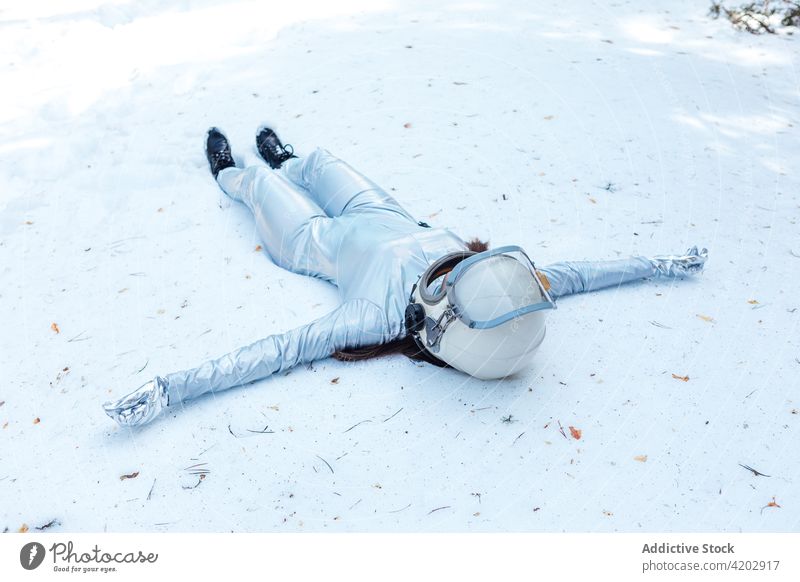 Frau im Raumanzug auf verschneiter Lichtung in der Natur liegend Astronaut Wald Lügen Waldwiese Schnee Raumfahrerin Kosmonaut Panzerung Tracht Windstille Winter