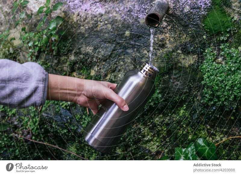 Reisende, die eine Flasche mit Wasser aus einer Quelle füllen natürlich besetzen eingießen Reisender frisch Hand Wanderer Frühling Natur trinken Lifestyle