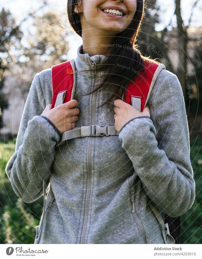 Anonyme Frau mit Rucksack beim Wandern im Wald Wanderer Glück Sonnenlicht aktiv heiter Natur Lächeln jung Lifestyle Aktivität Erholung Wellness Gesundheit