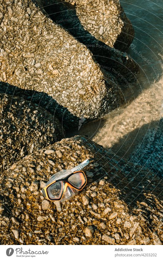 Nahaufnahme einer Taucherbrille auf einem Felsen am Strand Wasser MEER abschließen Urlaub Sommer reisen Schutzbrille Natur tropisch Meer blau Feiertag
