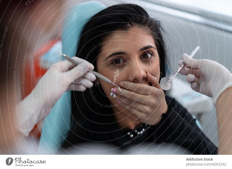 Verängstigter Patient, der den Mund mit den Händen vor dem Zahnarzt verschließt Frau Angst furchtbar geduldig Medizin Spezialist Arbeit erschrecken Deckel Mund