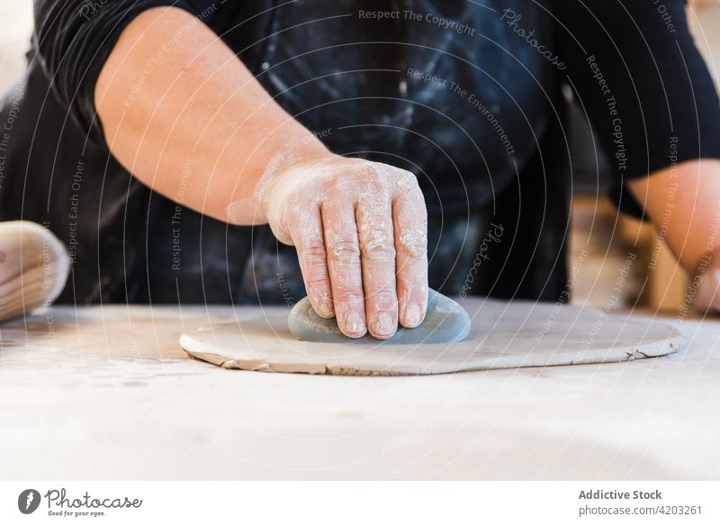 Crop Person, die Kreise aus Ton ausschneidet Bildhauer ausschneiden kreisen Werkstatt Prozess Fähigkeit Handwerk Form Künstler Leiste Basteln professionell