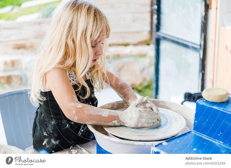 Kleines Kind lernt Töpfern in der Werkstatt Töpferwaren Rad Ton Topf Form Mädchen Frau kreativ Hobby wenig Fähigkeit handgefertigt dreckig Prozess Vase Tisch