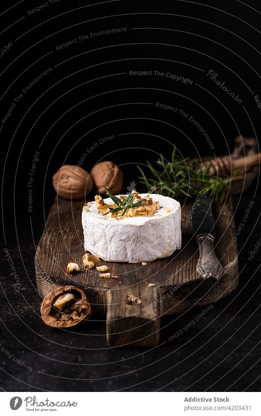 Camembertkäse mit Walnüssen auf Holzbrett Käse Walnussholz Feinschmecker Lebensmittel frisch Rosmarin Brie weiß ganz kulinarisch Gastronomie Tradition