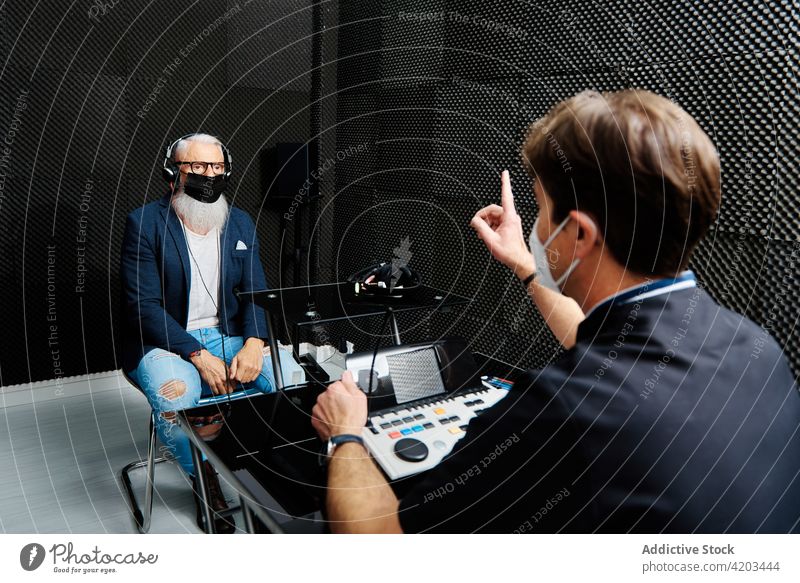 Älterer Mann und Arzt im Raum für einen audiologischen Test Audiologie Prüfung prüfen geduldig Senior hören Klang Diagnostik untersuchen männlich Mundschutz