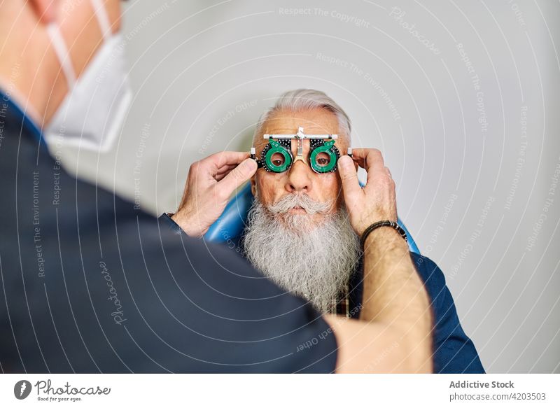 Optometrist und älterer Mann mit Sehtestbrille Optometrie Diagnostik Augenlicht Brille Prüfung Ophthalmologie Arzt geduldig Senior Augenoptikerin Sehvermögen