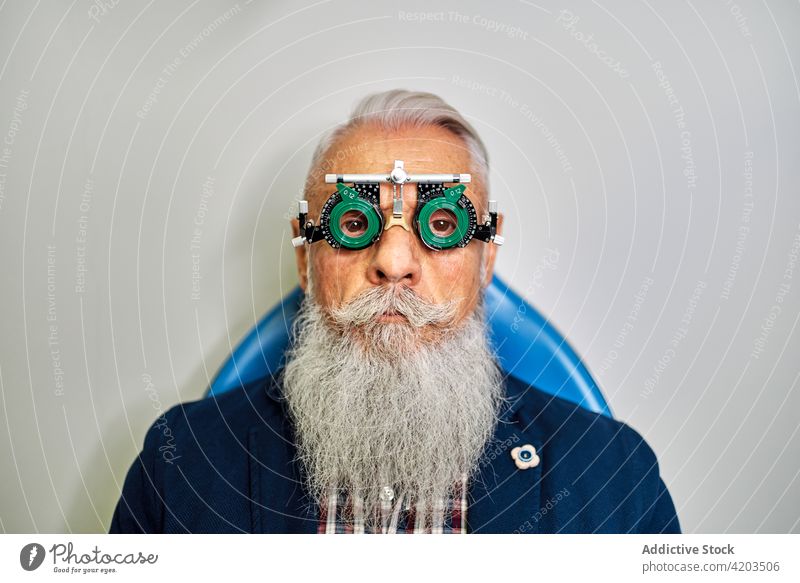Älterer Mann mit Sehtestbrille in der Klinik Brille Optometrie Diagnostik Augenlicht Prüfung geduldig untersuchen Sehvermögen Senior männlich Ophthalmologie