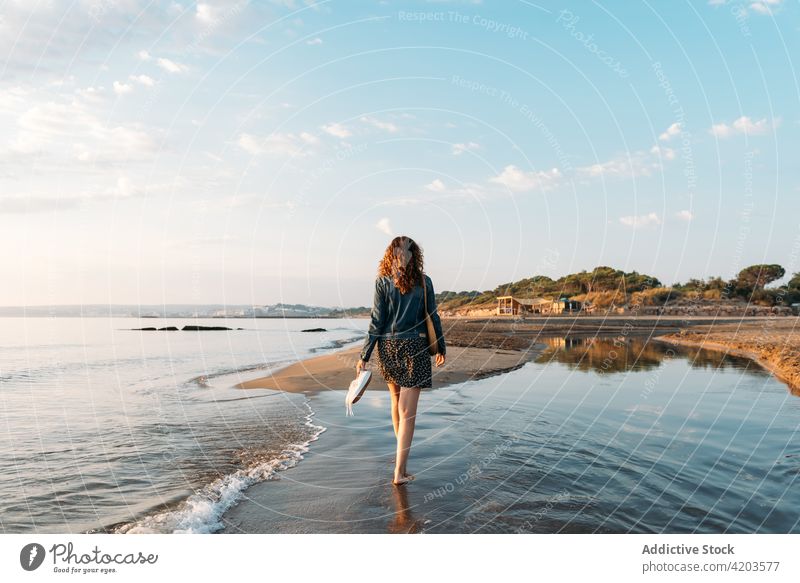 Anonyme Frau geht gegen Meer und Sonnenuntergang Himmel MEER Spaziergang bewundern Sommer Wasser ruhig Landschaft Abend spektakulär Natur Gelassenheit malerisch