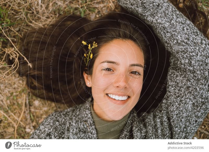 Glückliche Frau auf einer Wiese liegend Gras Natur Lächeln Blume genießen Porträt Frühling heiter jung Menschliches Gesicht Reisender positiv Blütezeit Inhalt