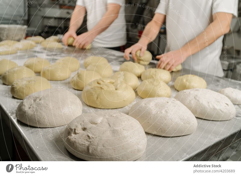 Anonyme Bäcker bereiten Brot am Tisch in der Küche vor vorbereiten Formular Teigwaren professionell Kollege natürlich Männer Bäckerei ethnisch Mitarbeiterin