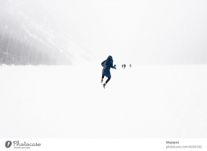 Junge Person springt in die Luft in einer Winterlandschaft mit Schnee. Gefrorener Lake Louise, Banff National Park, Alberta, Kanada Natur schön Freiheit