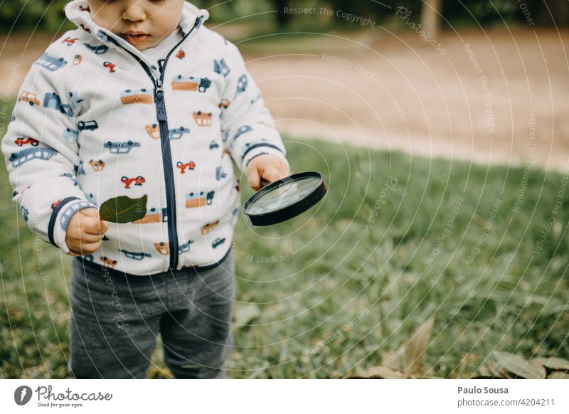 Kind spielt mit Lupe 1-3 Jahre Kaukasier erkunden Neugier Glück Fröhlichkeit Farbfoto Natur Freude Kindheit Lifestyle Außenaufnahme Mensch mehrfarbig
