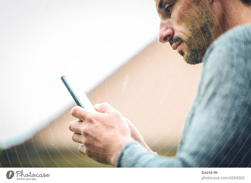 Mann benutzt ein Handy tippen Internet Mobile Smartphone Hände digital Nachricht Gesicht Lesen online