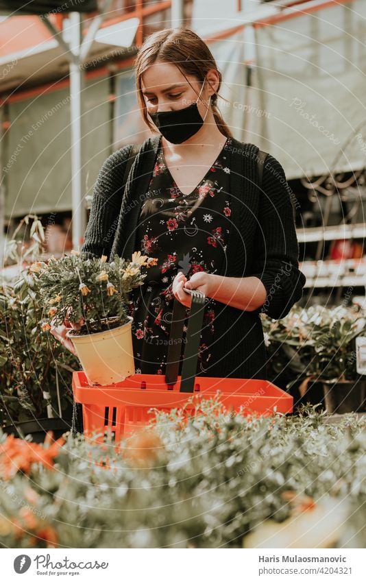 Junge Frau kauft Blumen für den Garten schön Blüte kaufen Pflege Kaukasier Zentrum heiter Wahl auserwählend wählte Nahaufnahme farbenfroh wirtschaftlich