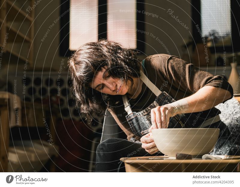 Keramikerin bei der Herstellung einer Tonschale im Atelier Töpferwaren Rad Handwerkerin kreieren Tonwaren Werkstatt Steingut Kunstgewerbler Frau Fokus