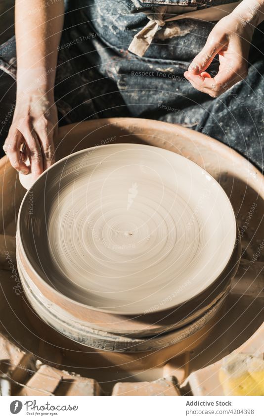 Töpferin stellt in ihrer Werkstatt Tonwaren her Handwerkerin Töpferwaren Rad kreieren Steingut handgefertigt Keramik Basteln Frau Kunst Kunstgewerbler Geschirr