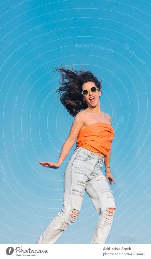 Hipster-Frau in trendigem Outfit springt gegen blauen Himmel Sommer Stil springen Blauer Himmel Sonnenbrille trendy Mode sorgenfrei Energie Fliege schweben