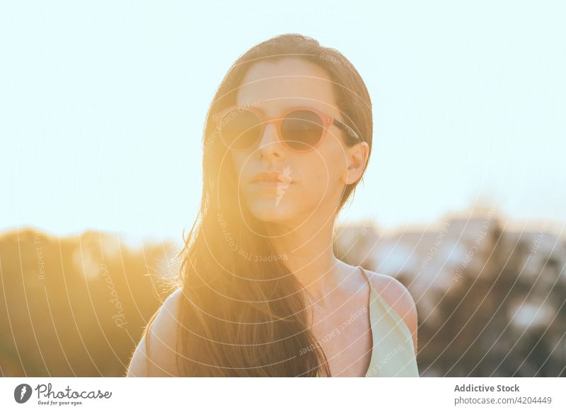 Stilvolle Frau mit Sonnenbrille genießt den Sommertag trendy selbstbewusst Mode Brille sonnig lange Haare Lifestyle jung modern urban Persönlichkeit Vorschein